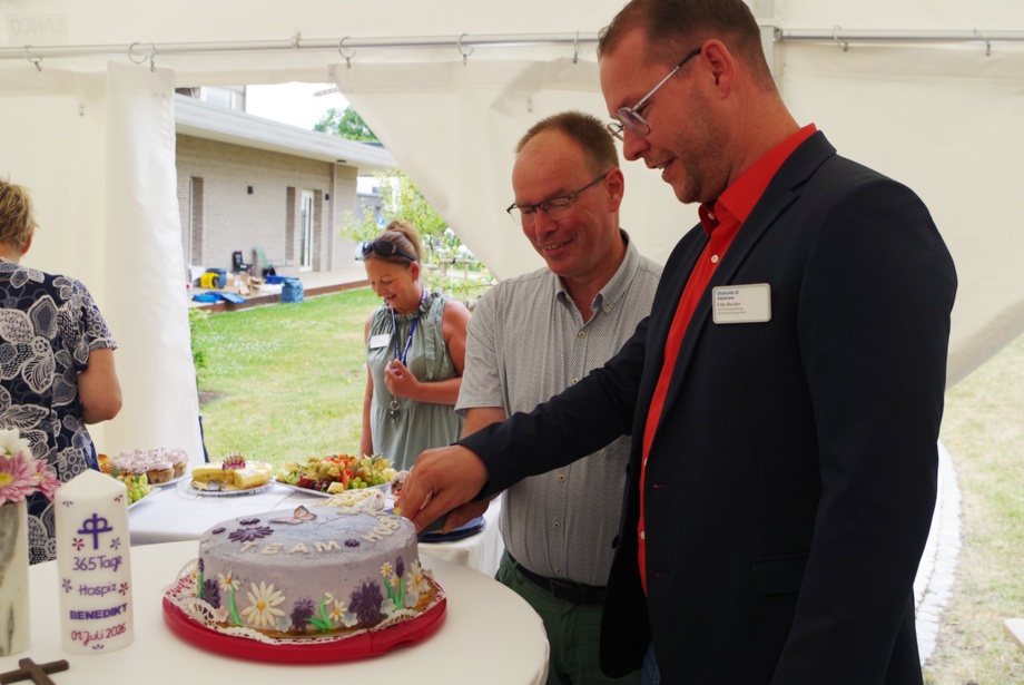 Vorstand Christoph Kupke und Einrichtungsleiter Felix Becker schneiden die Jubiläumstorte an Bild